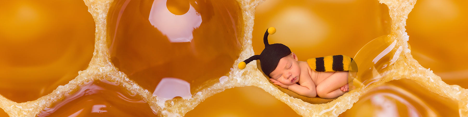 Baby in bee costume in a giant honey comb to represent that Manuka Honey Baby products such as soaps, baths and washes are a natural premium and gentle option