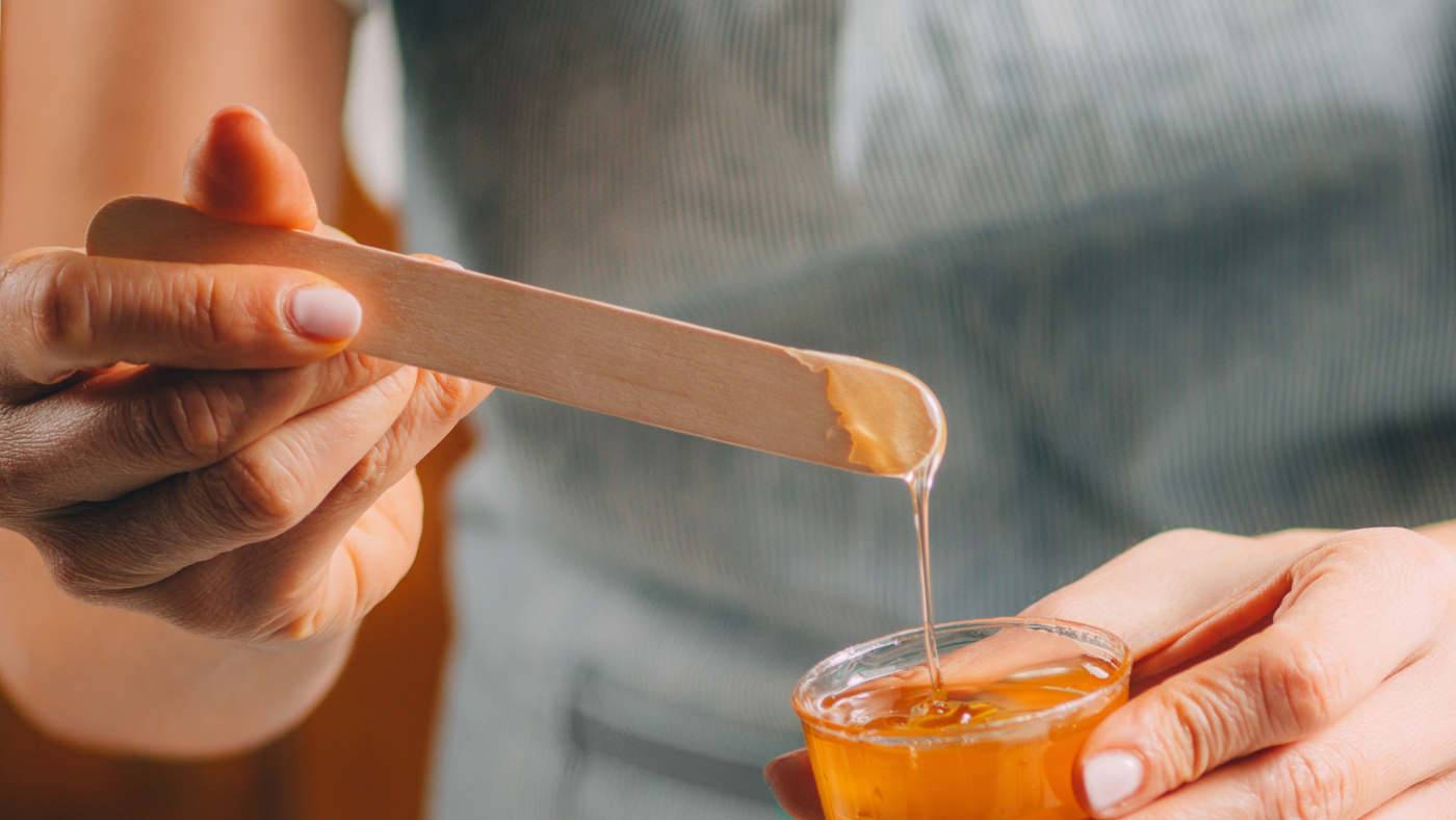 honey dripping of a wooden dipper held by a woman - The Healing Power of Manuka Honey for Burns & Wounds