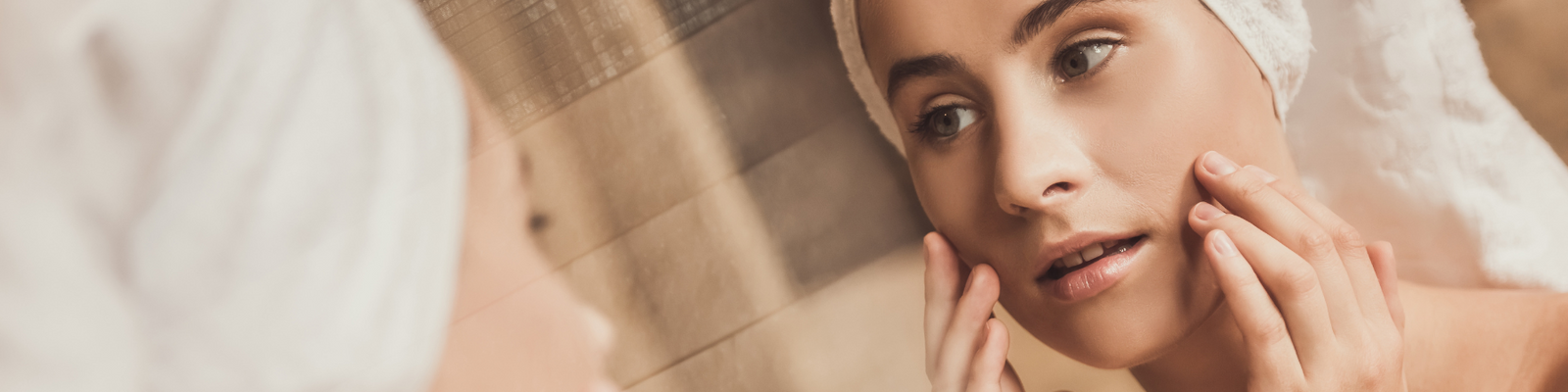 young lady looking at her face in the mirror