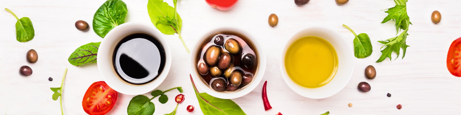Manuka Honey sauces and dips on table with olives and fresh produce sprinkled around