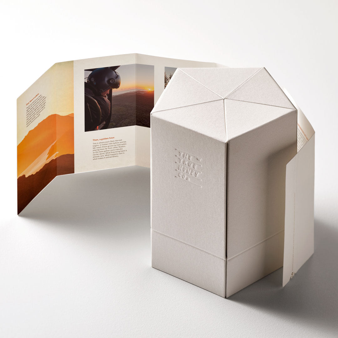Geometric box with a printed cover featuring a landscape and text on a white background