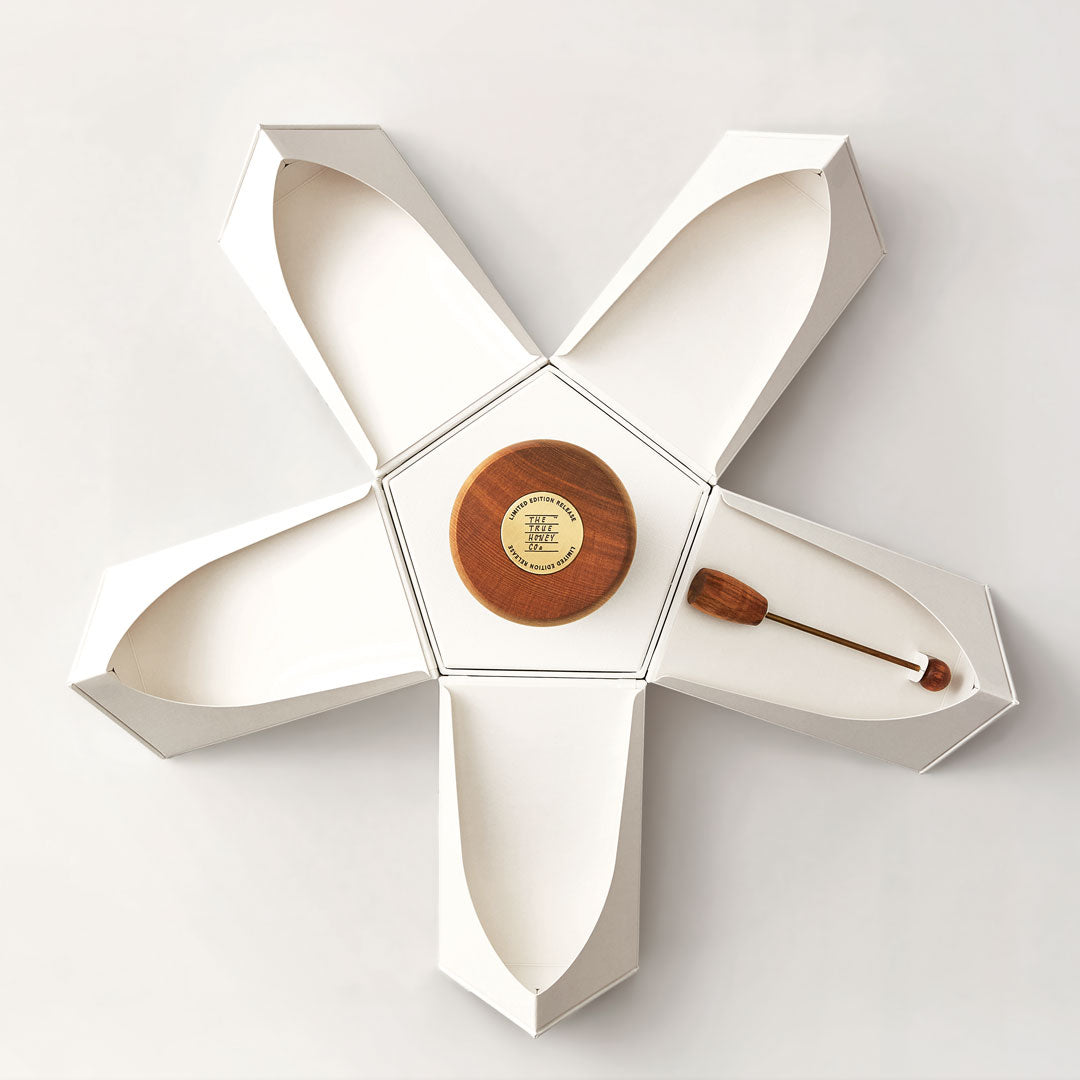Rare Harvest True Honey 35.2 UMF Decorative wall piece with geometric design and wooden components on a white background