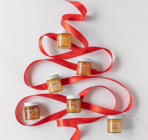 Jars of a product arranged in a decorative pattern with red ribbons on a white background