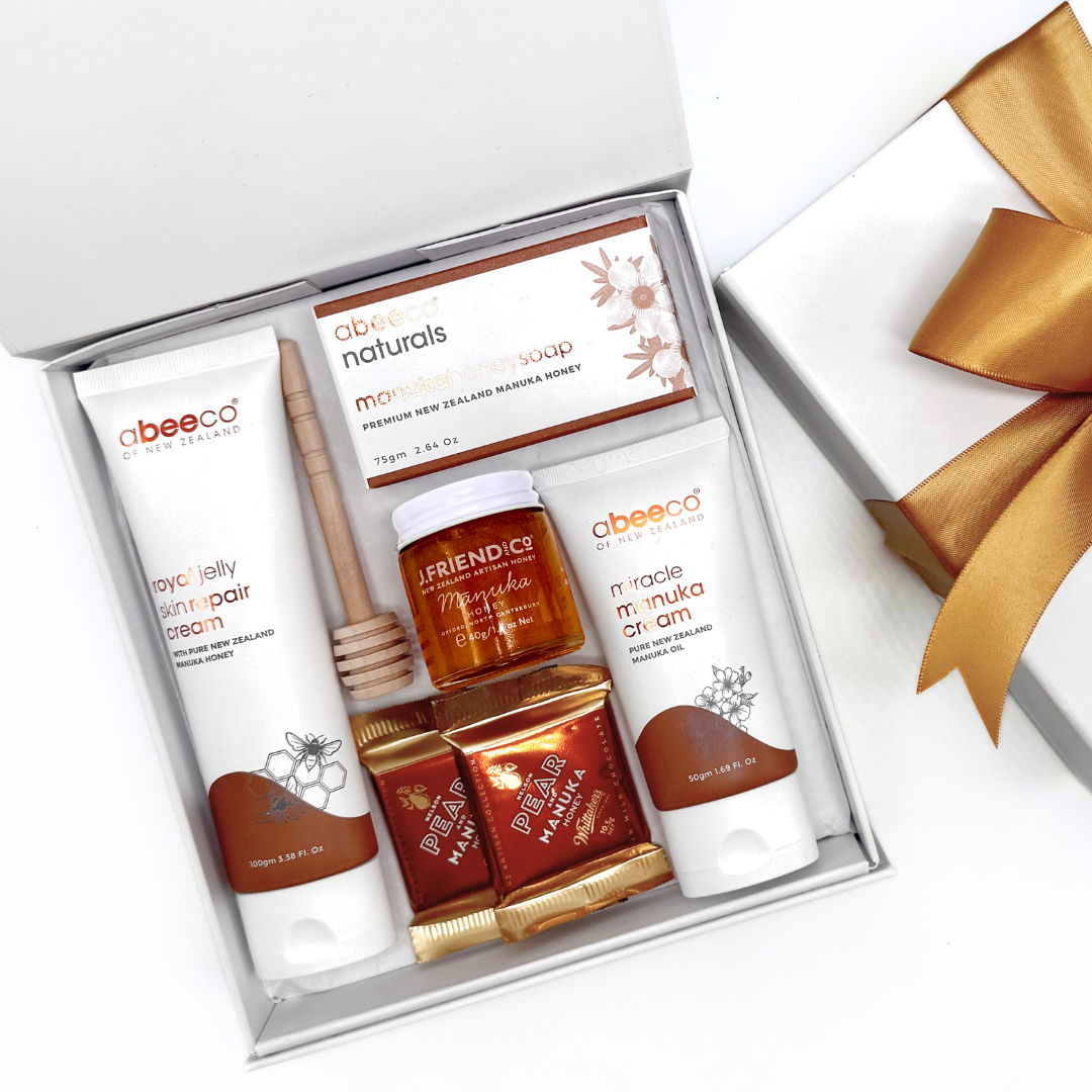 Gift set with abeecc and Friend & Co skincare products in a box with a gold bow.