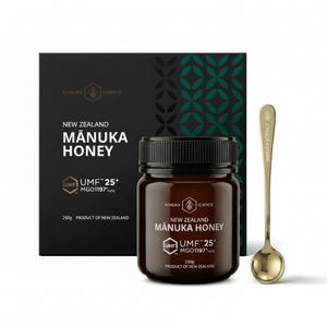 A jar of Manuka Science New Zealand Manuka Honey is shown in front of its black packaging box, with a gold spoon on a clean white background.