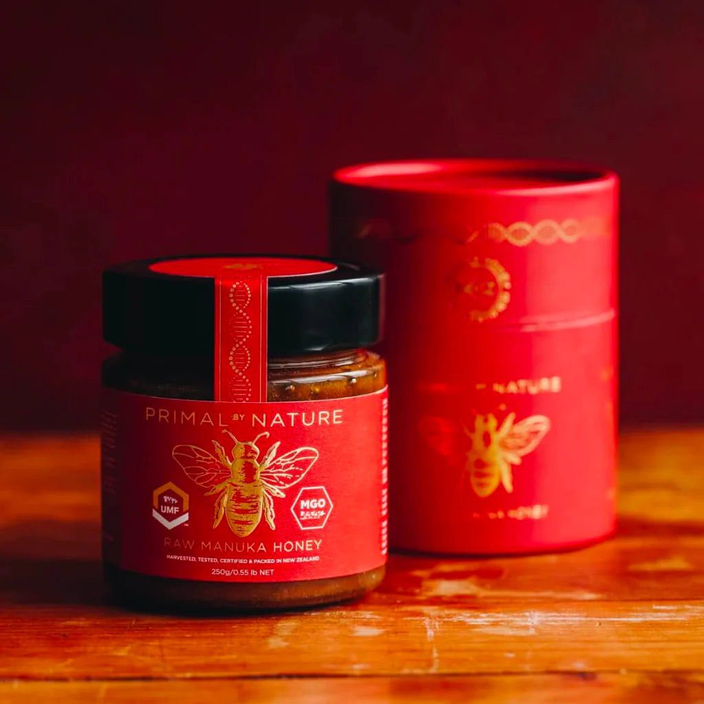 Two jars of Primal Nature Raw Manuka Honey on a white background