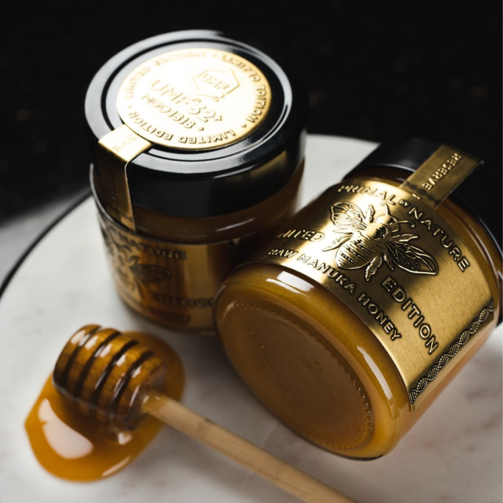 A honey dipper lifting from the jar, the honey falling slowly