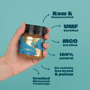 Hand holding a jar of Steens Manuka Honey with certification text on a teal background