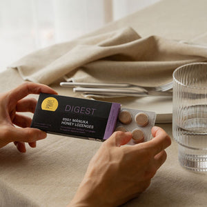 person holding digest lozenges at a table