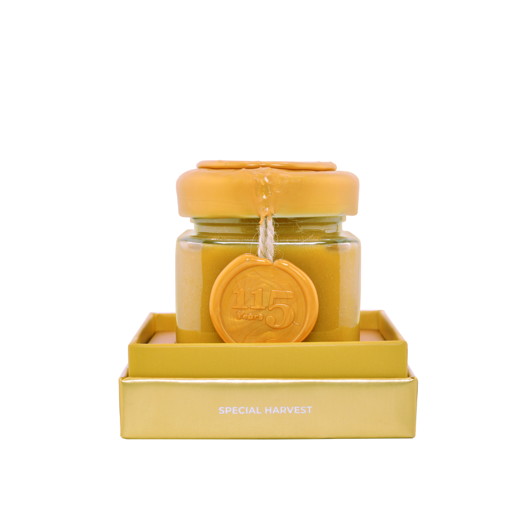 Jar of honey with a yellow lid on a white background